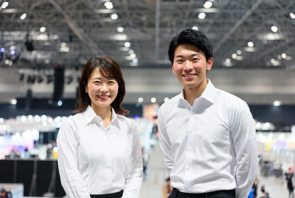 イベント会社・株式会社East Shipは関東の東京/世田谷と関西/京都を中心にイベントを一貫して運営。大規模イベント会場での白襟付きYシャツの若い女性スタッフと男性スタッフ